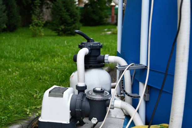 Pool filter tank and pump connected beside an above-ground pool