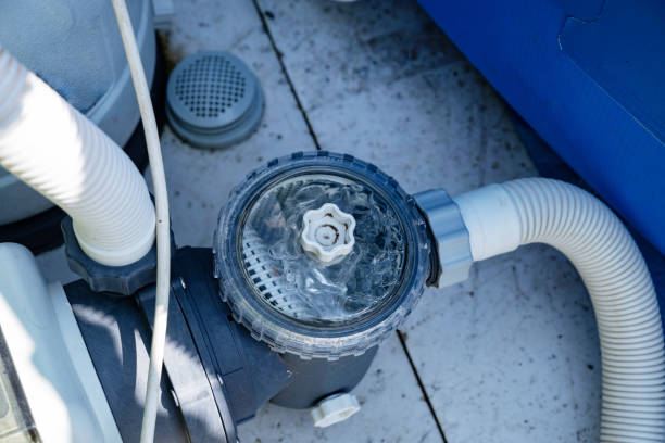 Close-up of a pool pump and strainer beside an above-ground pool