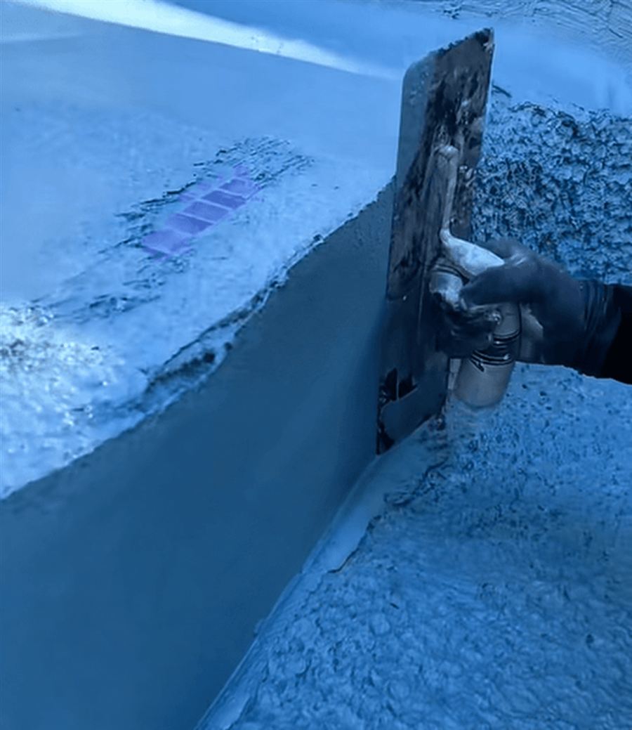 Close-up of a trowel shaping the finish around a pool step